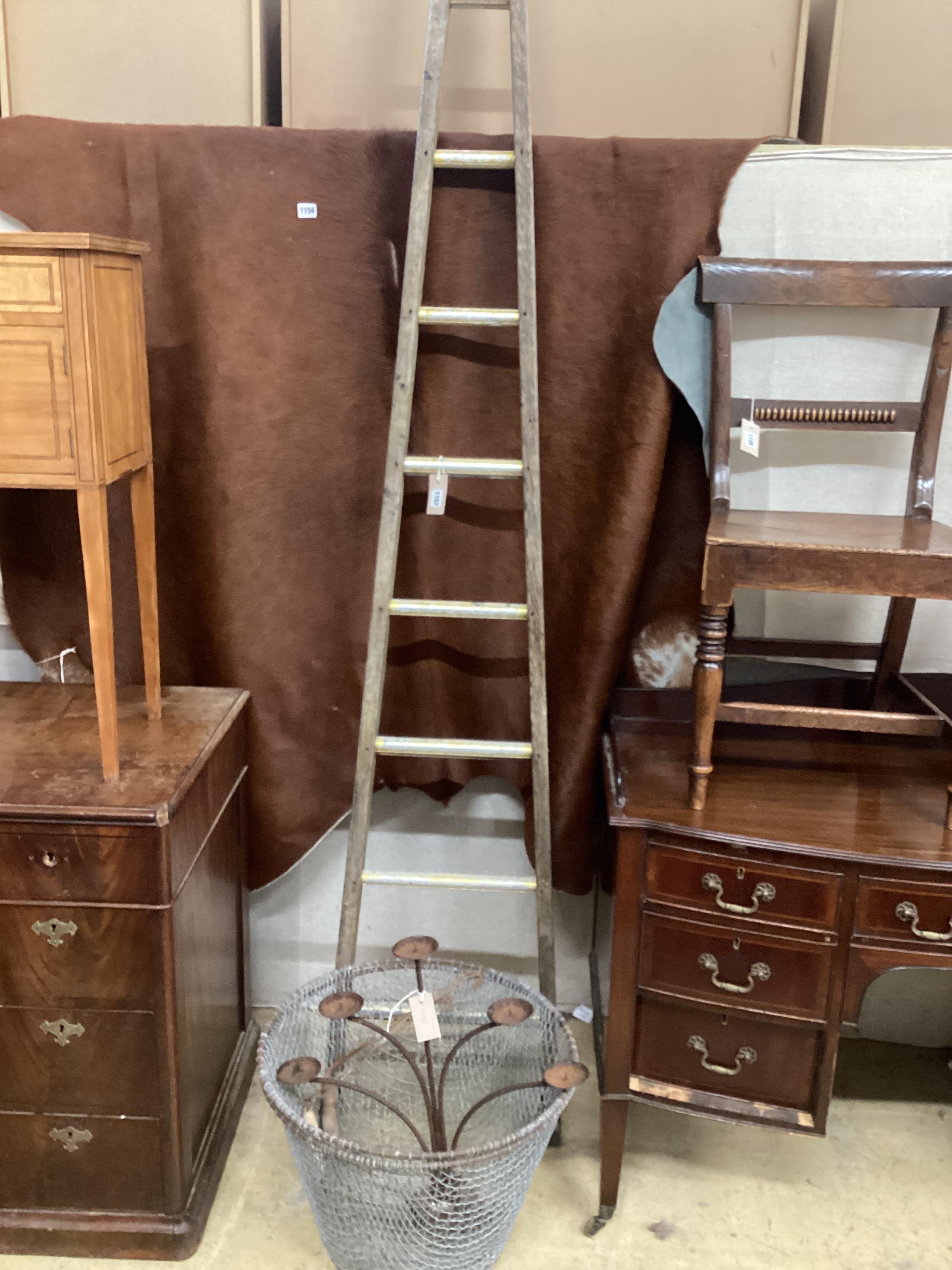 A vintage wooden window cleaner's ladder, height 250cm, two wirework garden baskets and a wrought iron candelabrum